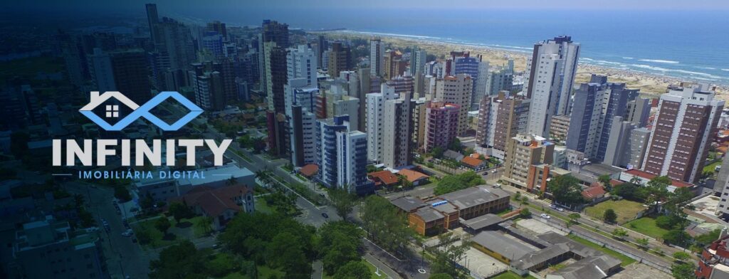 Prédios e casas próximos a praia em Torres, Rio Grande do Sul. O logo da Infinity Imobiliária Digital à esquerda.