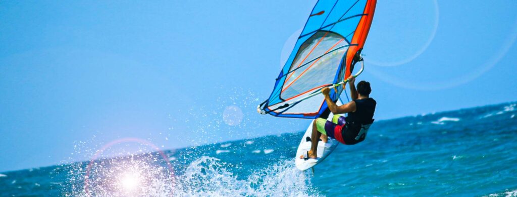 Prática do esporte radical aquático windsurf.