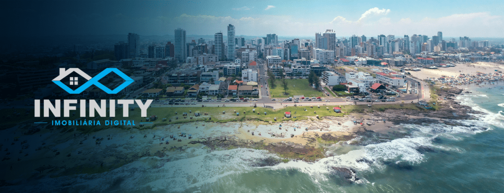 Turistas na areia de uma praia em Torres, no Rio Grande do Sul, com a logo da Infinity Imobiliária Digital à esquerda.